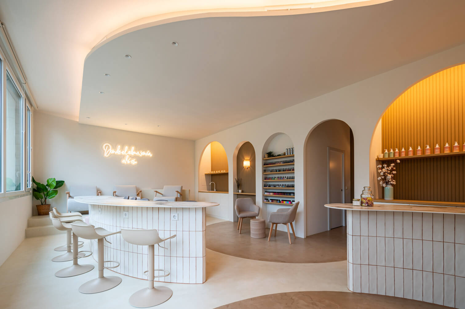Interior Le Maise Valdebebas — salón con arcos, barra de mármol y neón