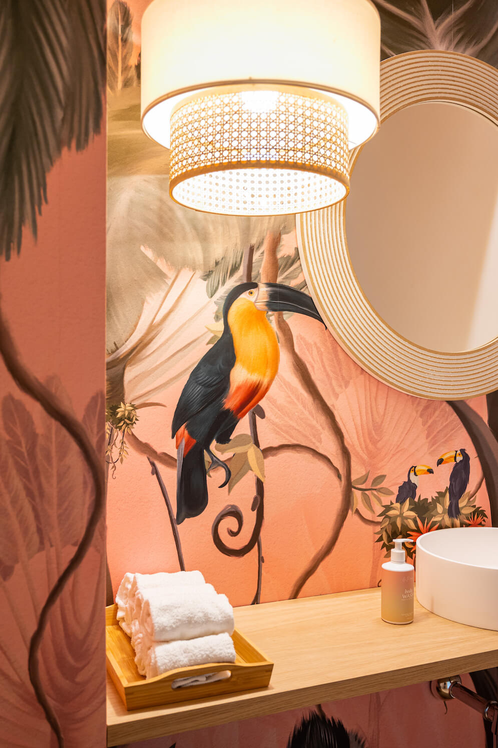 Baño con mural tropical y productos Le Maise en Valdebebas